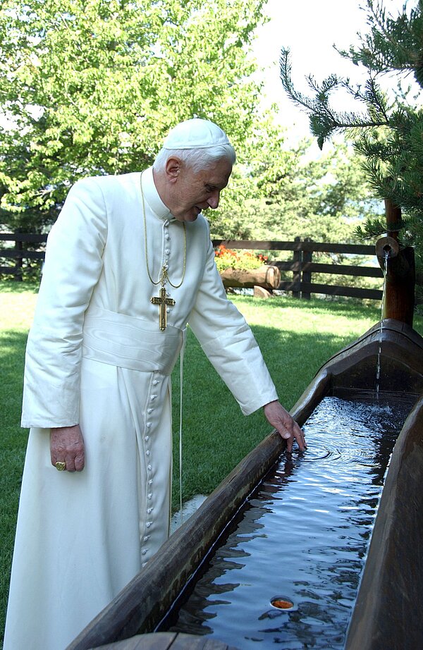 Papst Benedikt XVI. im Urlaub im italienischen Aosta-Tal bei Les Combes am 17. Juli 2006. Der Papst taucht seine Hand ins Wasser an einem Brunneneinlauf im Garten.