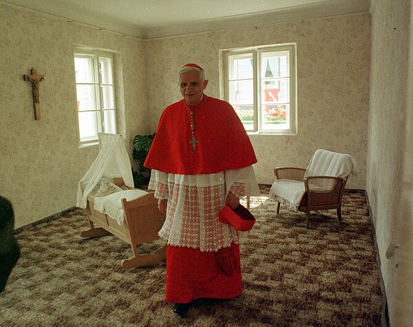 Joseph Kardinal Ratzinger besichtigt das Zimmer in Marktl am Inn, in dem er 1927 geboren wurde (Foto von 1997). 1997 wurde der jetzige Papst Benedikt XVI. Ehrenbürger seiner bayerischen Geburtstadt